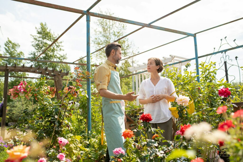 Owner of flower shop or garden center talking to one of clients